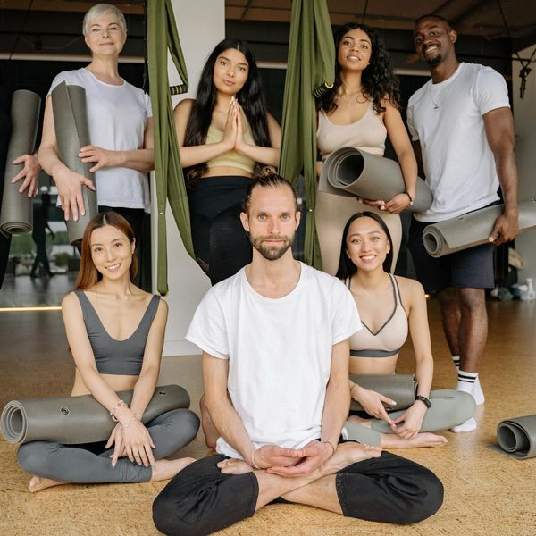 A group of diverse women smiling during a yoga class.